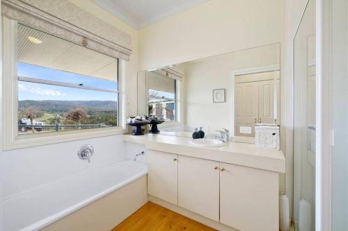 baño blanco con lavabo y ventana en IRONBARK FARM Farmhouse on 52 acres in the scenic Yarra Valley, en Glenburn