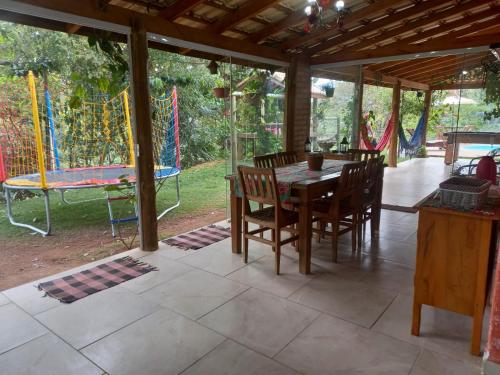 ラゴイーニャにあるAconchegante Sítio em Lagoinha SPのパティオ(テーブル、椅子、プレイグラウンド付)