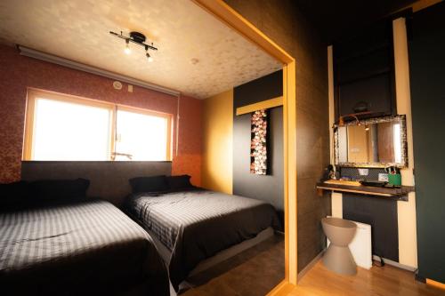 een kleine slaapkamer met 2 bedden en een raam bij Sapporo Bios Kan 522 - Vacation STAY 10918 in Sapporo