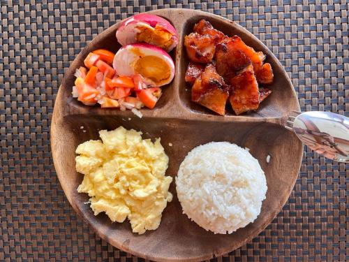 a plate of food with rice and vegetables on a table at Tabularasa - T Palawan in San Vicente