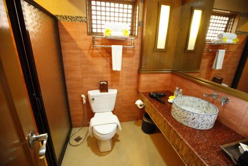 a bathroom with a toilet and a sink and a mirror at Boracay Tropics Resort Hotel in Boracay