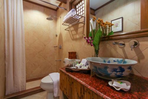a bathroom with a bowl sink and a toilet at Boracay Tropics Resort Hotel in Boracay