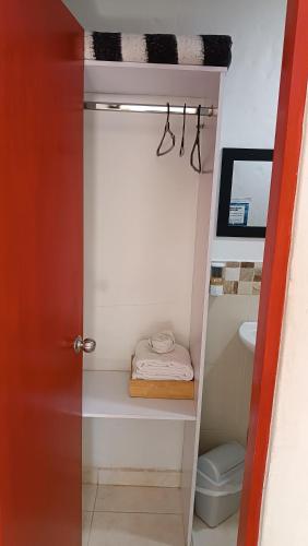 a bathroom with a closet with a sink and a toilet at Hotel Marrokos Aeropuerto José María Córdova in Rionegro