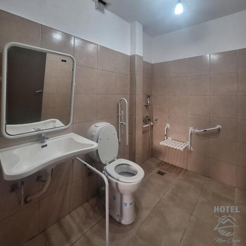a bathroom with a toilet and a sink and a mirror at Hotel Mon Chéri in Villa Carlos Paz