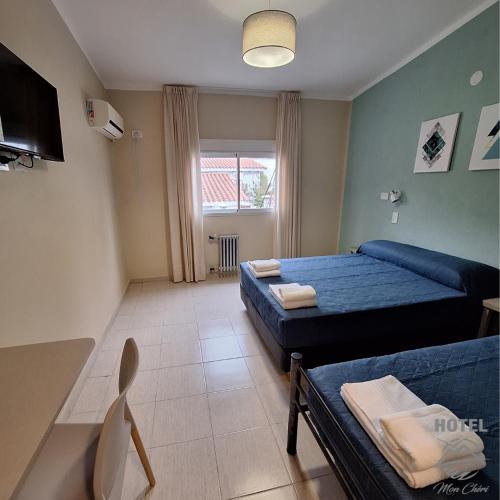 a small room with two beds and a television at Hotel Mon Chéri in Villa Carlos Paz