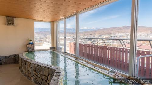 a swimming pool in a balcony with a view of a city at Yumotoya in Matsumoto