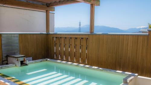 a swimming pool in a house with a wooden fence at Yumotoya in Matsumoto