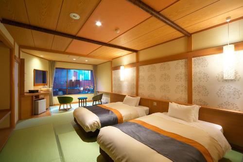 a hotel room with two beds and a desk at Umiusagi in Higashiizu