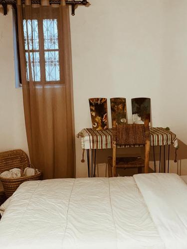 a bedroom with a bed and two chairs and a window at Tarbi'aat Tetaoun 44, 17th century heritage in Tetouan