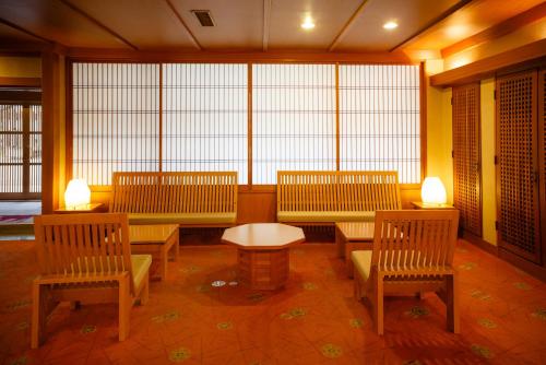 a room with three benches and a table and windows at Yumotoya in Matsumoto