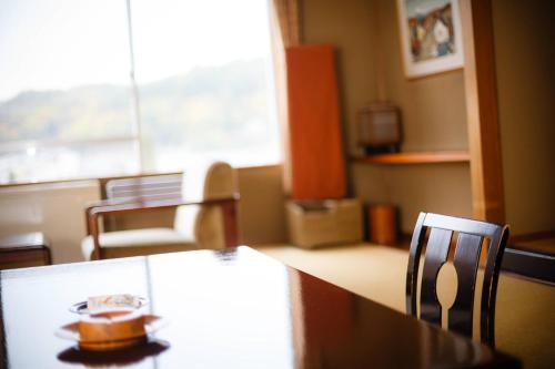 a dining room with a table and chairs and a window at Yumotoya in Matsumoto