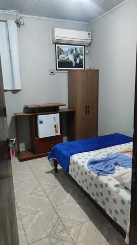a bedroom with a bed and a desk and a tv at Pousada ji Paraná in Ji-Paraná