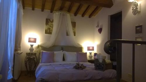 a bedroom with a large bed with a canopy at Piccolo Relais Galletto di Marzo Spa e relax solo per due in Paciano
