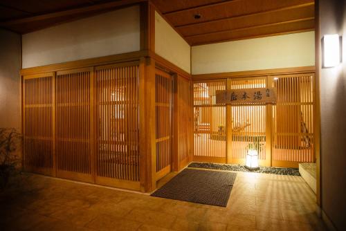 an empty room with a door and a lamp in it at Yumotoya in Matsumoto