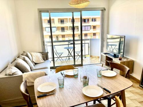 un salon avec une table avec des chaises et un canapé dans l'établissement Appartement traversant, proche plage, 2 balcons, pets ok, ménage inclus, jusqu’à 8 pers, Port-la-Nouvelle - FR-1-229C-94, à Port-la-Nouvelle