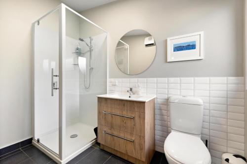 a bathroom with a shower and a toilet and a sink at Fletcher Cottage in Arrowtown