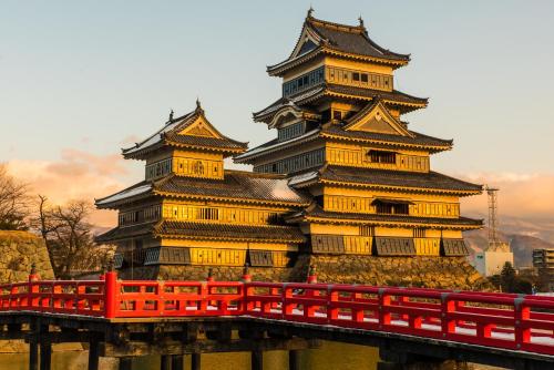 a large building with a red bridge in front of it at Yumotoya in Matsumoto