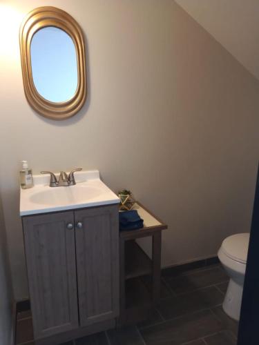 a bathroom with a sink and a toilet and a mirror at Sunrise Apartments in Rosarito