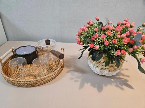 a basket and a vase of flowers on a table at Gyeongju happy house in Gyeongju