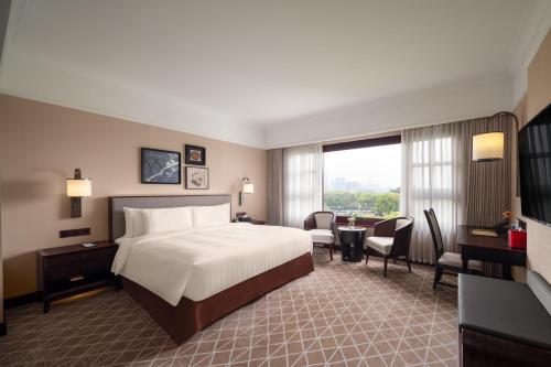 蘇州市にあるPan Pacific Suzhouのベッドとデスクが備わる広い客室です。
