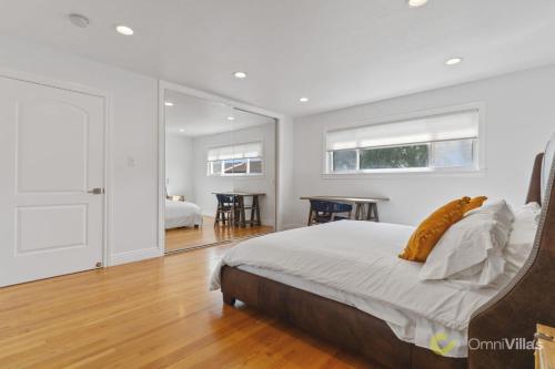 Stunning 3BR in Foster City في مدينة فوستر: غرفة نوم بيضاء مع سرير ومرآة