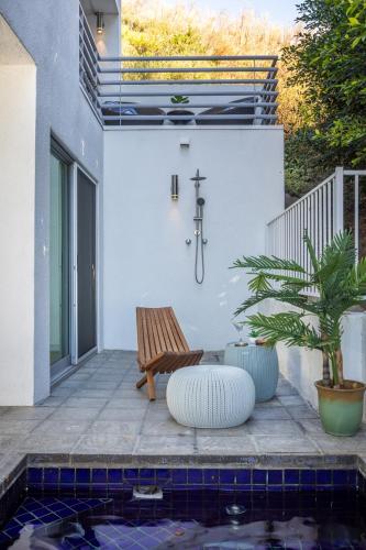 a bench sitting on a patio next to a pool at Malibu Breeze - hot tub, ocean view, steps to beach in Malibu