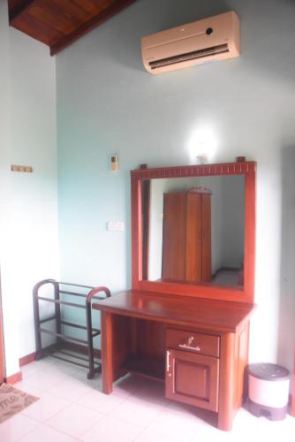 a mirror sitting on top of a wooden desk at Rathna Gems Halt in Ratnapura