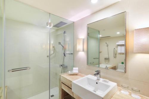 une salle de bain avec un lavabo et une douche dans l'établissement Holiday Inn Wuhan Riverside by IHG, à Wuhan