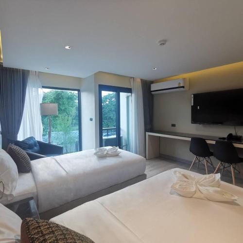 a hotel room with a large bed and a flat screen tv at The 9 Residence Hotel in Bangkok