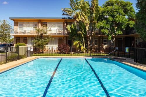 a large swimming pool in front of a building at Forster Holiday Lodge 4 in Forster