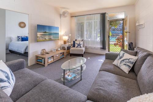 a living room with a couch and a bed at Forster Holiday Lodge 4 in Forster