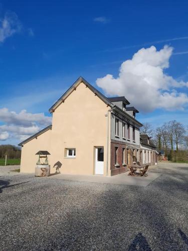 un grand bâtiment blanc sur le côté d'une route dans l'établissement Maison jusqu'à 8 personnes, à Doudeville