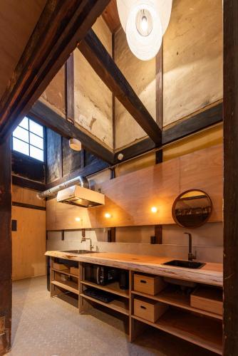 a large kitchen with wooden ceilings and a large island at Machiya Hotel YANAGI in Kyoto