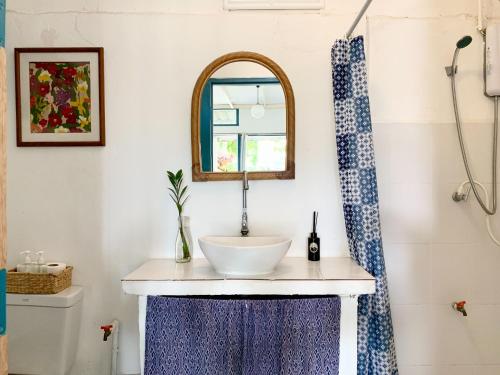 W łazience znajduje się umywalka i lustro. w obiekcie Ban Narai River Guesthouse w mieście Chiang Mai