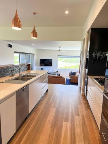 a kitchen with a sink and a living room at Martyrs Lookout - Luxury Accommodation in Peterborough