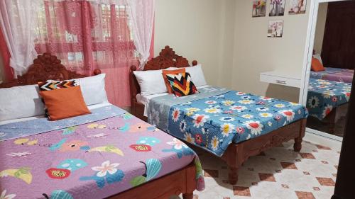 1 dormitorio con 2 camas y espejo en Village Guest House, en Casboran