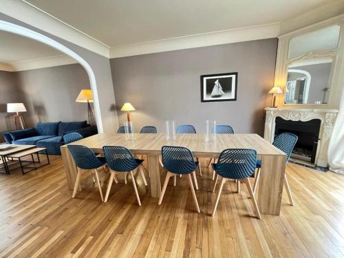 un salon avec une table et des chaises en bois dans l'établissement Villa Maignan 15 couchages 24h Le Mans, au Mans