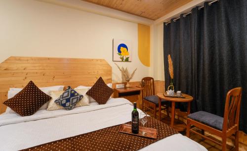 ein Hotelzimmer mit einem Bett, einem Tisch und Stühlen in der Unterkunft Orchard ArtHouse in Manali