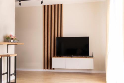 uma sala de estar com uma televisão de ecrã plano num armário branco em Apartament Kościuszki Chorzów em Chorzów