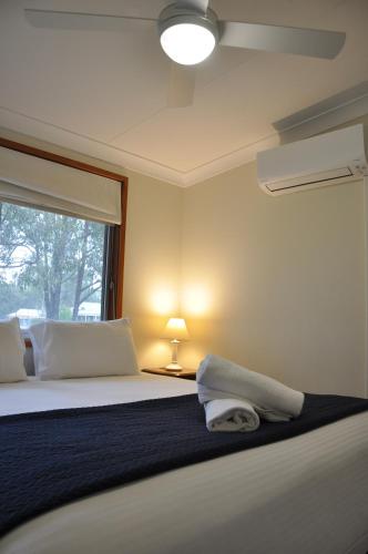 a bedroom with a large bed with a window at Pokolbin Village Estate in Pokolbin