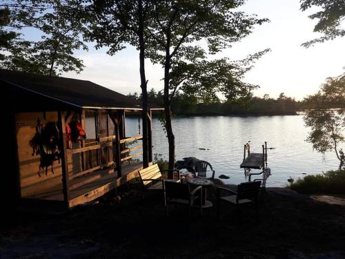 a house with a table and chairs next to a lake at The Eagle's Landing on Minamkeak Lake - A Serene Escape in Italy Cross