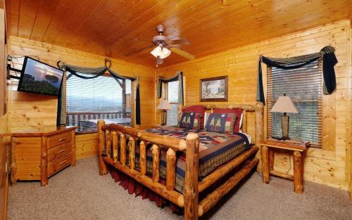 ein Schlafzimmer mit einem Bett in einem Blockhaus in der Unterkunft Star Gazer in Sevierville