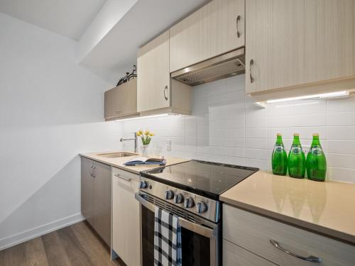 a kitchen with green bottles on the counter at Sleek 1BR & office Condo - CN Tower, Skyline view in Toronto