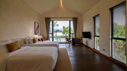 a hotel room with two beds and a television at Sanhe Daoli Resort in Qingyuan