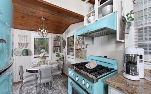 uma cozinha com um fogão azul e um lavatório em River Romance em Gatlinburg