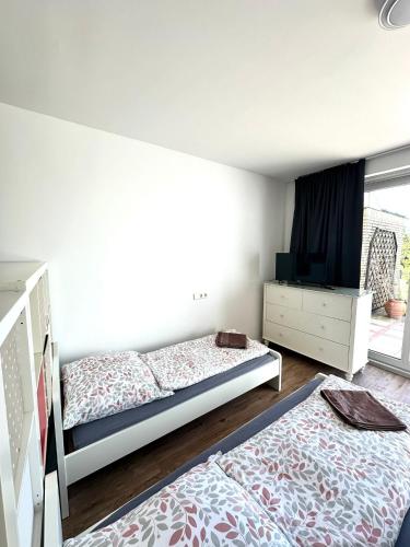 a bedroom with two beds and a tv and a dresser at Top Monteurwohnung Stuhr-Brinkum mit perfekter Anbindung in Stuhr