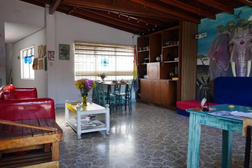 Almarita Casa Belga في ميديلين: غرفة معيشة مع أريكة حمراء وطاولة
