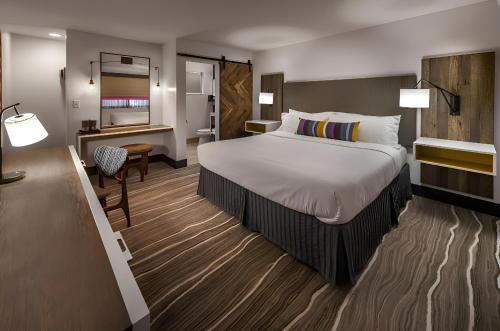 a hotel room with a large bed and a desk at Hotel Becket, BW Signature Collection in South Lake Tahoe