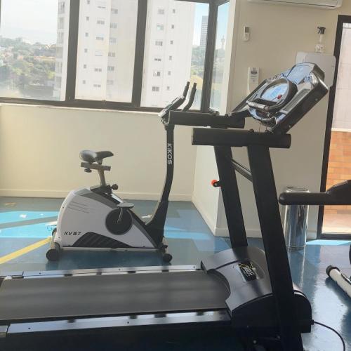 a gym with a treadmill in a room with windows at São Paulo Nações Unidas - Luxury Suíte in São Paulo