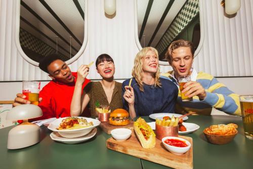 a group of people sitting at a table eating food at The Standard, Bangkok Mahanakhon in Bangkok